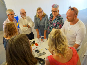 Personer som står kring Annelie på Enter när hon berättar rolig fakta om plast