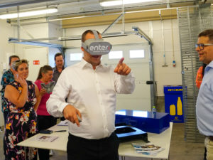 En man står med ett par VR glasögon på sig.