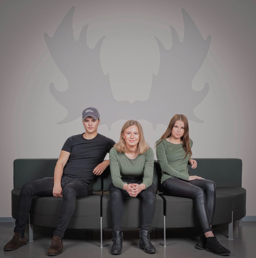 De tre medlemmarna i Uf företaget Venandi sitter i en soffa med sitt stora älghorn målat på väggen bakom sig